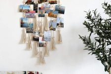 a boho wall hanging with tassels and photos hanging on ropes and macrame on it is very cool to DIY