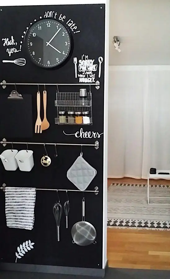 a chalkboard wall with railings, holders, hooks, a clock and lots of notes here and there is ideal for a kitchen