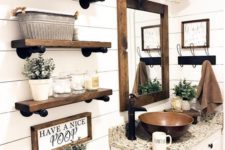 a chic farmhouse bathroom with white plank walls, stained wooden shelves, a white vanity and a metal sink