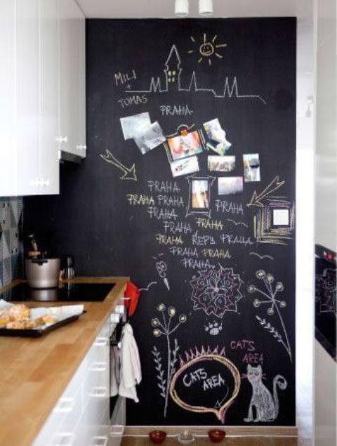a contemporary white kitchen with a chalkboard wall that is pure art, your kids will love it