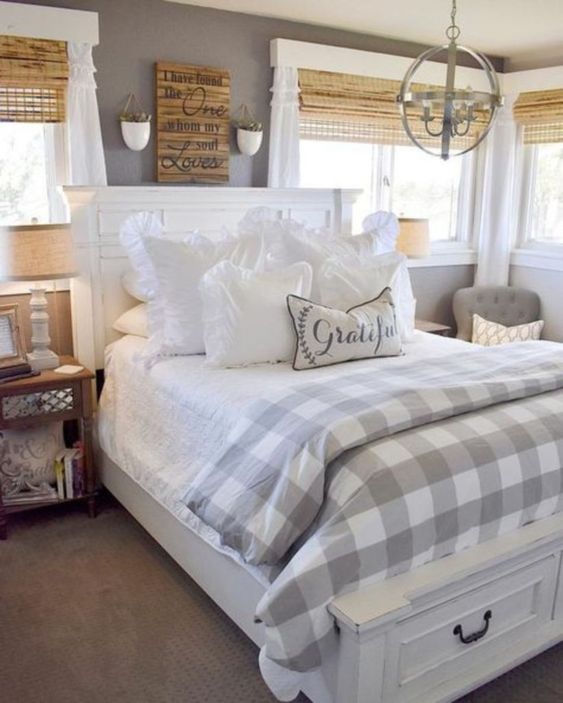 a cozy farmhouse space with wooden shades, checked textiles, a rustic artwork and carpet flooring