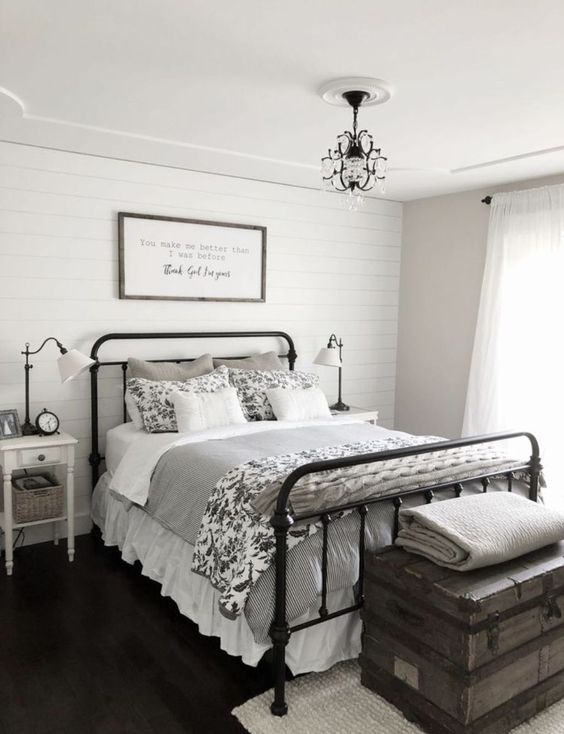 a modern farmhouse bedroom in a monochromatic color scheme, with much grey and printed textiles