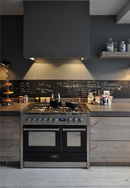 a modern industrial space with a small chalkboard backsplash and lights looks very rough and masculine, still rather inviting