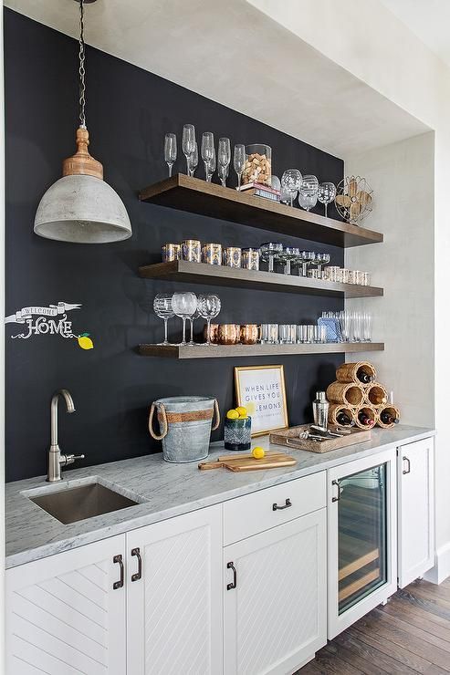a modern neutral kitchen with a chalkboard wall, open shelving and a pendant lamp is a stylish and cool space