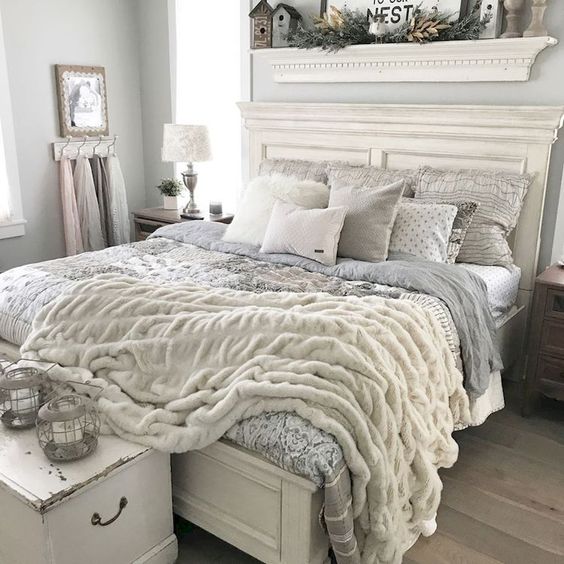 a vintage farmhouse bedroom done in neutrals, with vintage furniture and soft textural textiles