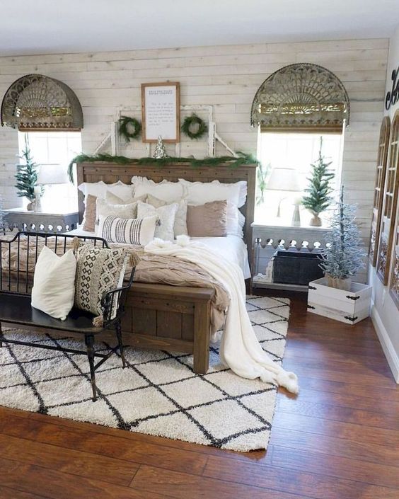 a vintage farmhouse bedroom with wooden furniture, a vintage bench, a rustic wooden bed and neutral textiles