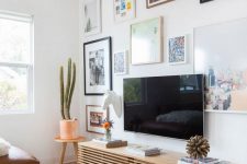 an eclectic gallery wall with bright photos and mismatching frames all over the wall is cool and bold