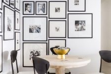 an elegant black and white gallery wall with matching black frames creating a mood in the dining nook
