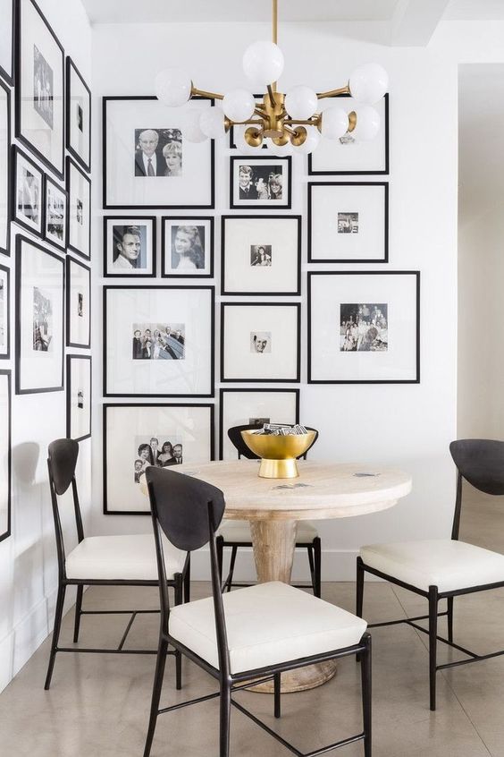 an elegant black and white gallery wall with matching black frames creating a mood in the dining nook