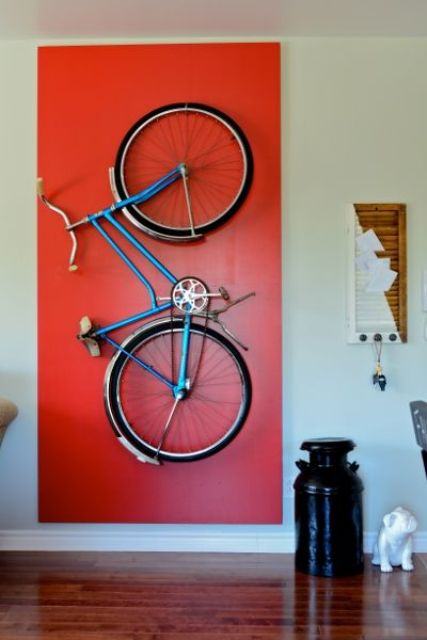 a holder for storing the bike on the wall and a bold red accent to highlight it is a very cool idea to accent what you really like