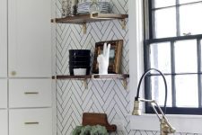 a white Scandinavian kitchen with a chevron tile wall, white stone countertops, brass and gold touches is super chic