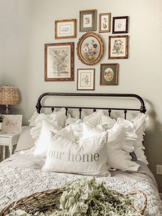 a beautiful and cozy vintage bedroom in neutrals, with a metal bed, a chic gallery wall, printed bedding and white nightstands