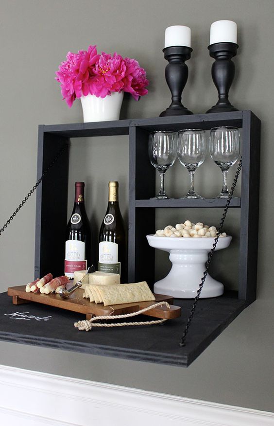 a chalkboard foldable wall-mounted bar with candles, wine, glasses and various appetizers