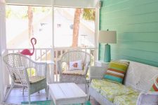 a colorful vintage sunroom with white wicker furniture, printed textiles, a pink flamingo and a blue lamp