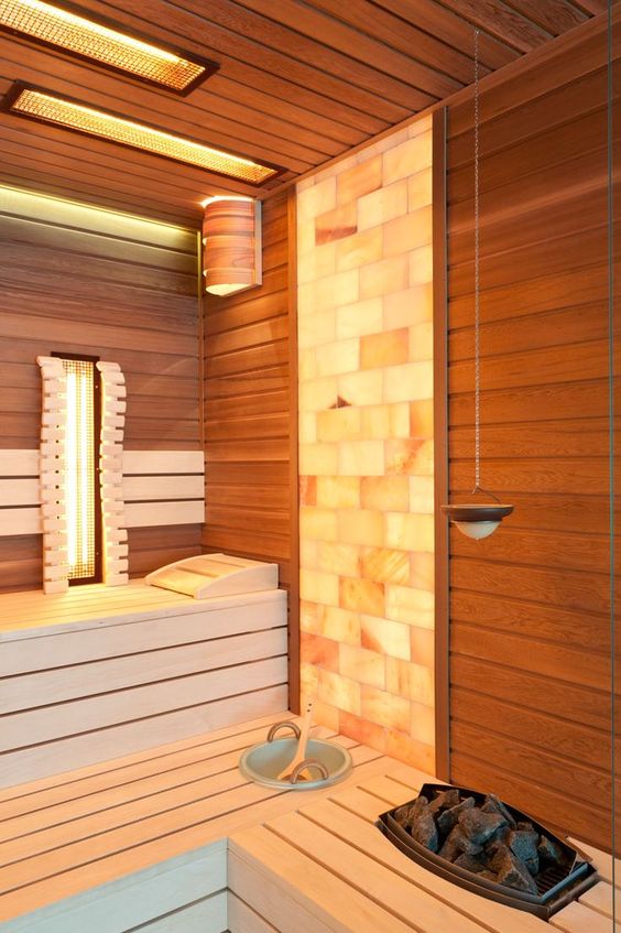 A cool steam room clad with wood and with a mosaic tile part, with some built in lights is bold and cozy