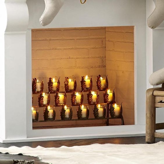 a fireplace with creative leafy candle holders on stands is a cool modern idea