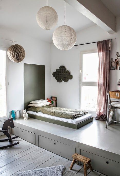 a grey platfrom raises the sleeping space and gives much storage space with drawers without clutter