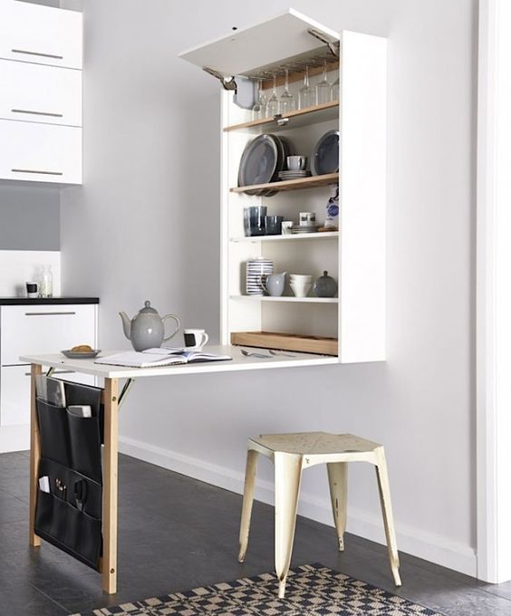 A minimalist wall mounted dining table with a large storage unit and a leather pocket for smaller stuff