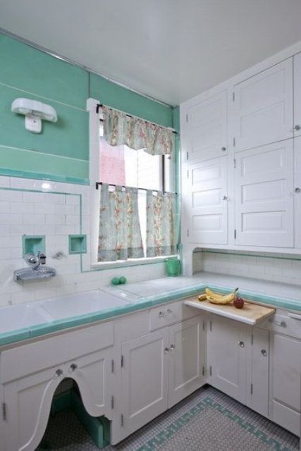 a neutral vintage kitchen with shaker style cabinets, bright turquoise touches and walls, floral curtains looks bright and very contrasting