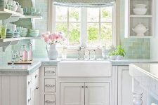 a pretty vintage cottage kitchen with white shaker style cabients, a green subway tile backsplash, open shelves and open cabinets and a printed curtain