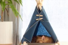 a raised cat teepee in navy is a cool space for your ufrry friend to sleep and to observe