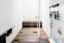 a raised wooden platform defines the shower space and a matching bench adds to the space