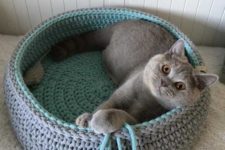 a round crochet cat bed with tassels in two colors is a stylish and cozy idea to rock