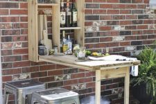 a rustic outdoor bar styled as a Murphy table is a geat idea for a small outdoor space to refresh yourself