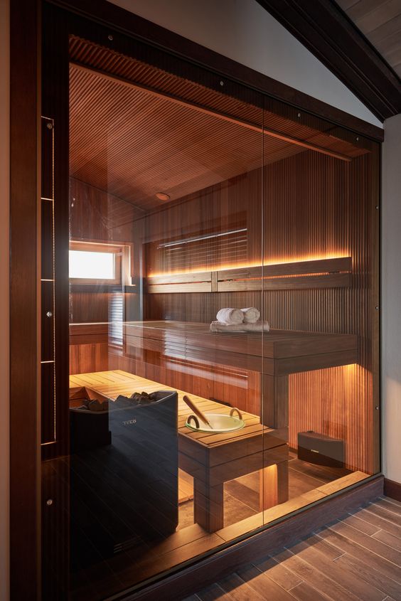 a small but gorgeous sauna done with two benches, clad with wood and built-in lights