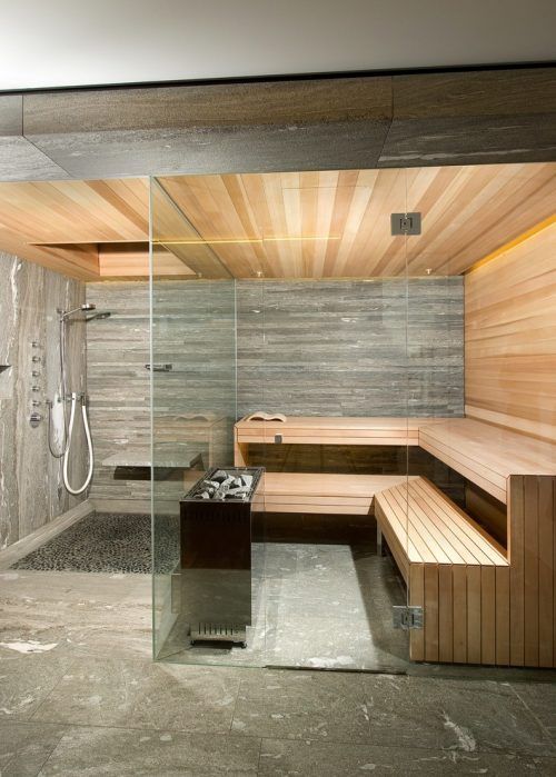 a small but very chic steam room clad with wood - light-stained and weathered and tiles plus built-in lights and glass walls