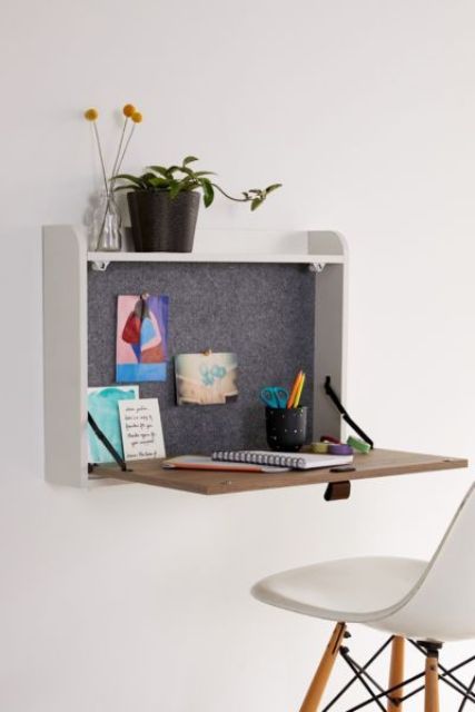 a small storage space with a foldable desk surface, some plants and felt inside the box is a cool idea