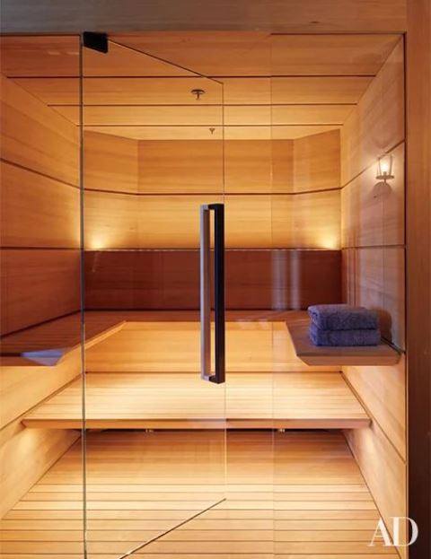 A small yet welcoming wood clad steam room with a couple of benches along the wall and built in lights
