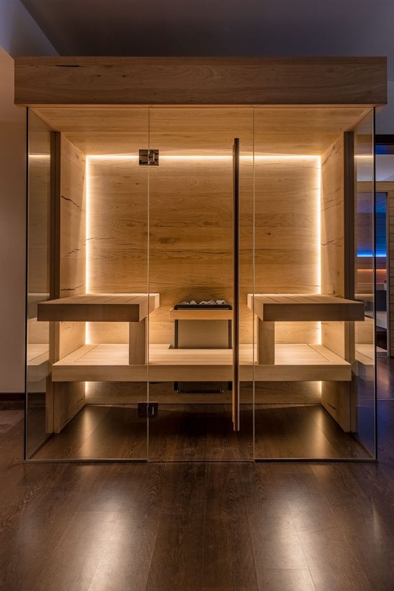A stylish modern wood clad sauna with built in lights and benches is very inviting and cool