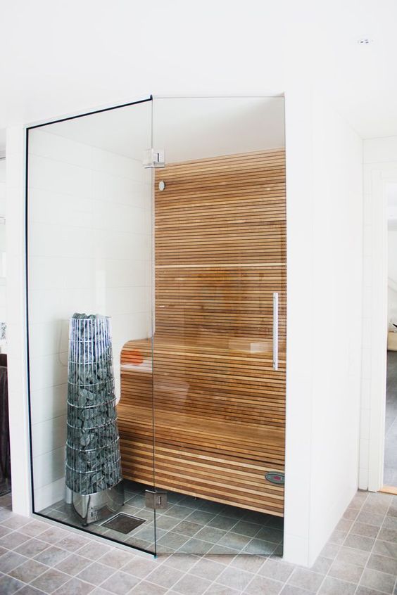 a tiny minimalist steam room clad with wood and with curved benches plus glass walls is cool