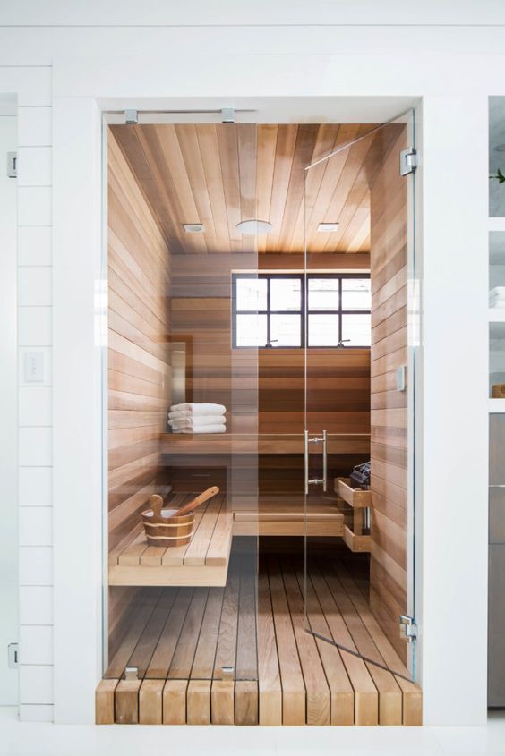 a tiny steam room with windows, a couple of long benches and some additional accessories is chic