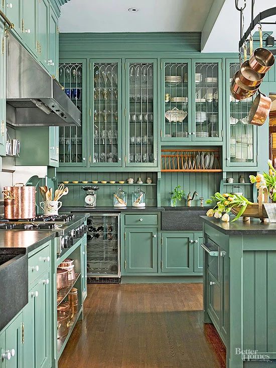 a vintage green kitchen with a beadboard backsplash, dark counertops, copper cookware and pans for decor is a bold and unusual idea