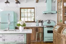 a vintage kitchen with stained cabinets, mint green appliances, a shabby chic kitchen island with green touches, wooden beams and vintage lamps