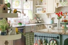 a vitnage cottage kitchen with white cabinets, a blue kitchen island, printed textiles, bright blooms and greenery and copper cookware