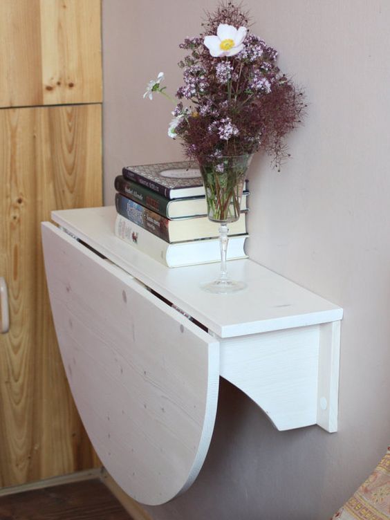 a white foldable wall-mounted desk or breakfast table is a great way to save some space