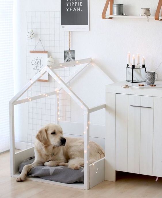 a white house-shaped dog bed with lights and a star-printed cushion is a pretty idea for a Scandinavian interior