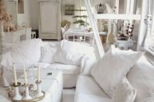 a white shabby chic living room with chic furniture, a white chest, white pillows and candles is very elegant
