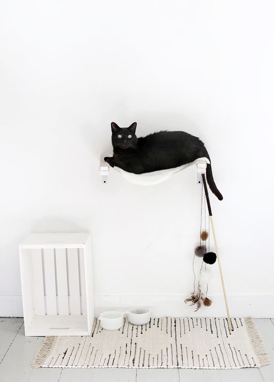 A white wall mounted hammock bed with toys attached is ideal for a Nordic space