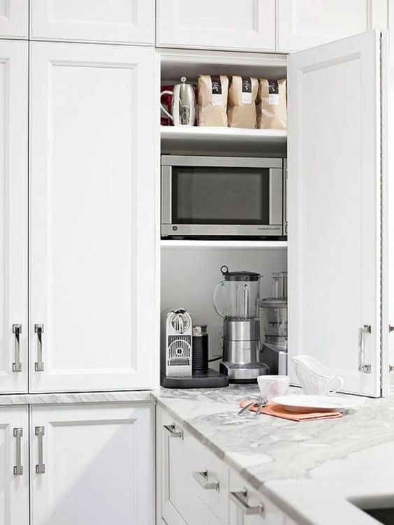 a cabinet with folding doors and some appliances and other stuff inside is a cool and smart idea for any kitchen