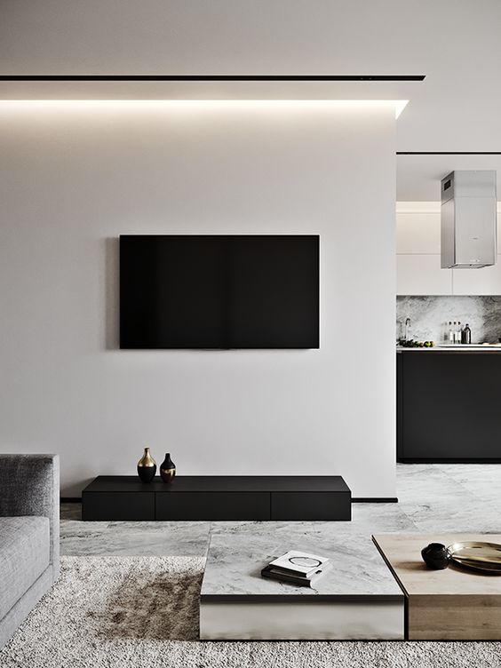 A contrasting living room in off white and black, laconic coffee tables, a textural rug and built in lights