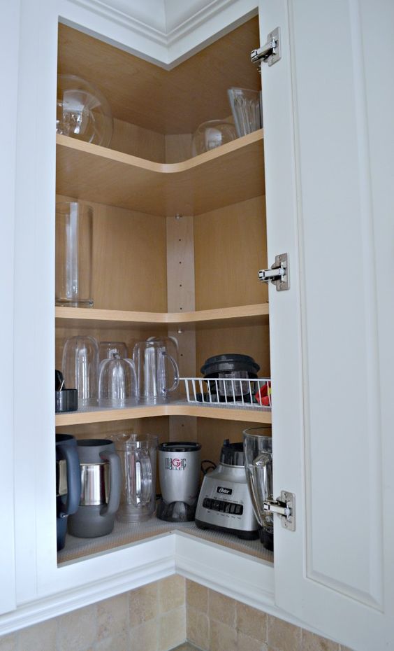 a corner cabinet with shelves that holds appliances and various mugs and glasses is a cool solution to save some space