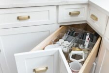 a corner drawer with gold handles is a cool idea to make the use of corner storage space, it’s a cool idea to get more storage from deep cabinets