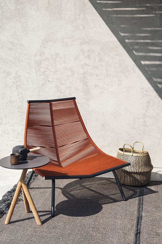 a creative lounger of a metal frame and some wicker in a rich brown shade looks really wow and really statement-like