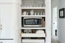 a functional cabinet with shelves and mini drawers holding glasses, mugs, cups and some appliances is a very smart idea