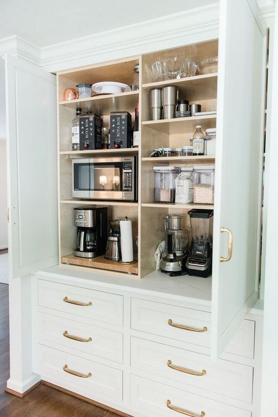 a large cabinet with all kinds of appliances, some bowls and jars is a cool idea to store what you don't need and hide it