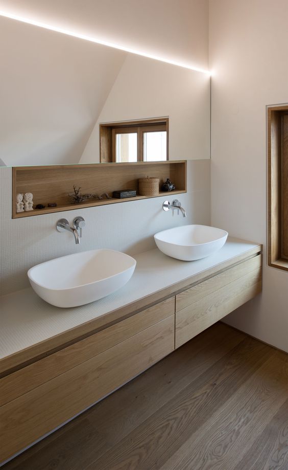 A long and narrow mirror with an additional built in open shelf is a cool and simple way to keep your minimalist bathroom sleek